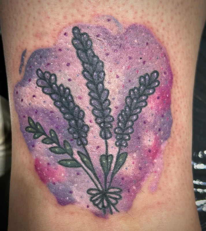 Watercolor lavender flowers tattoo on a woman's ankle.